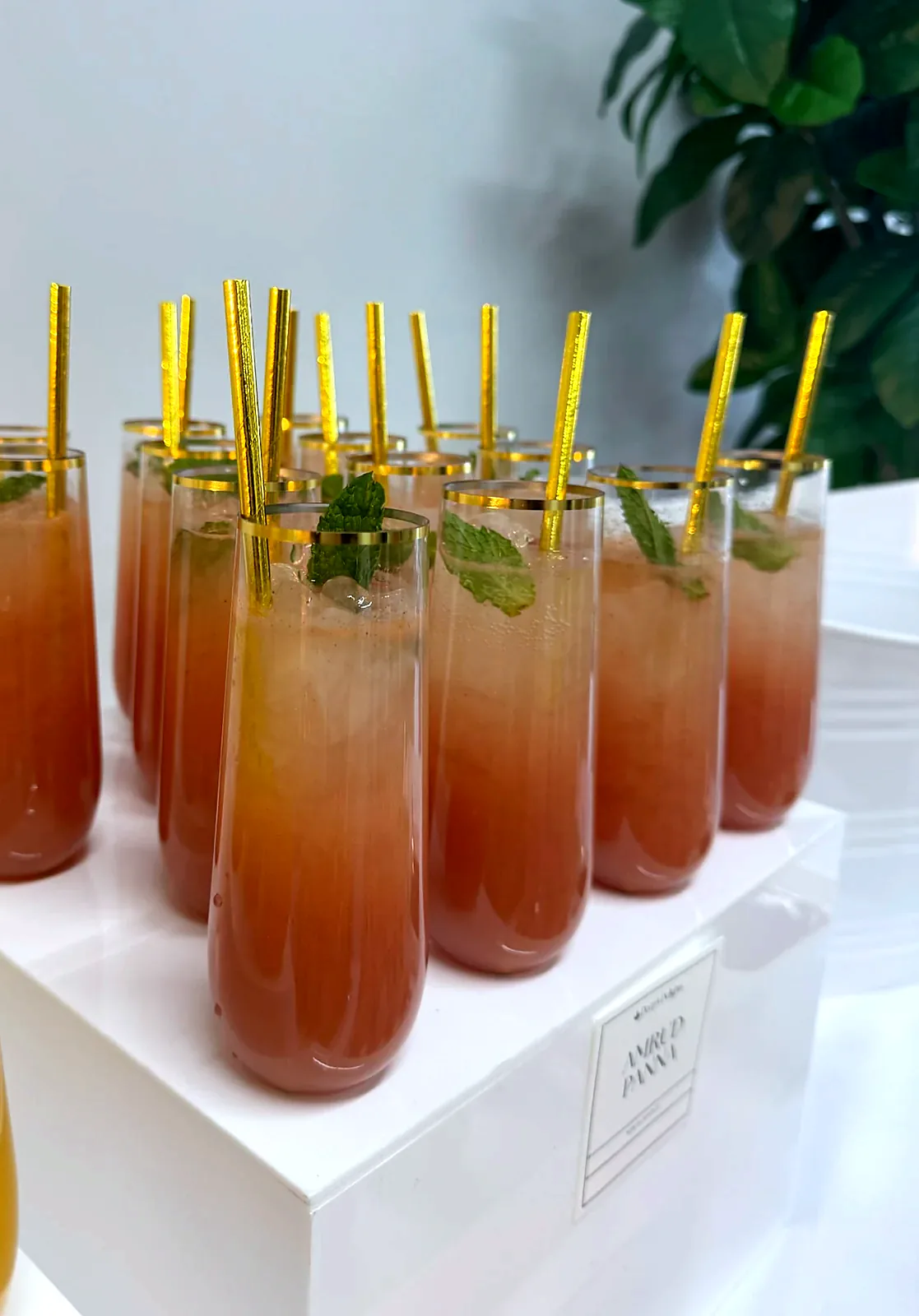Amrud Panna guava mocktails with mint and gold straws on a white display cube