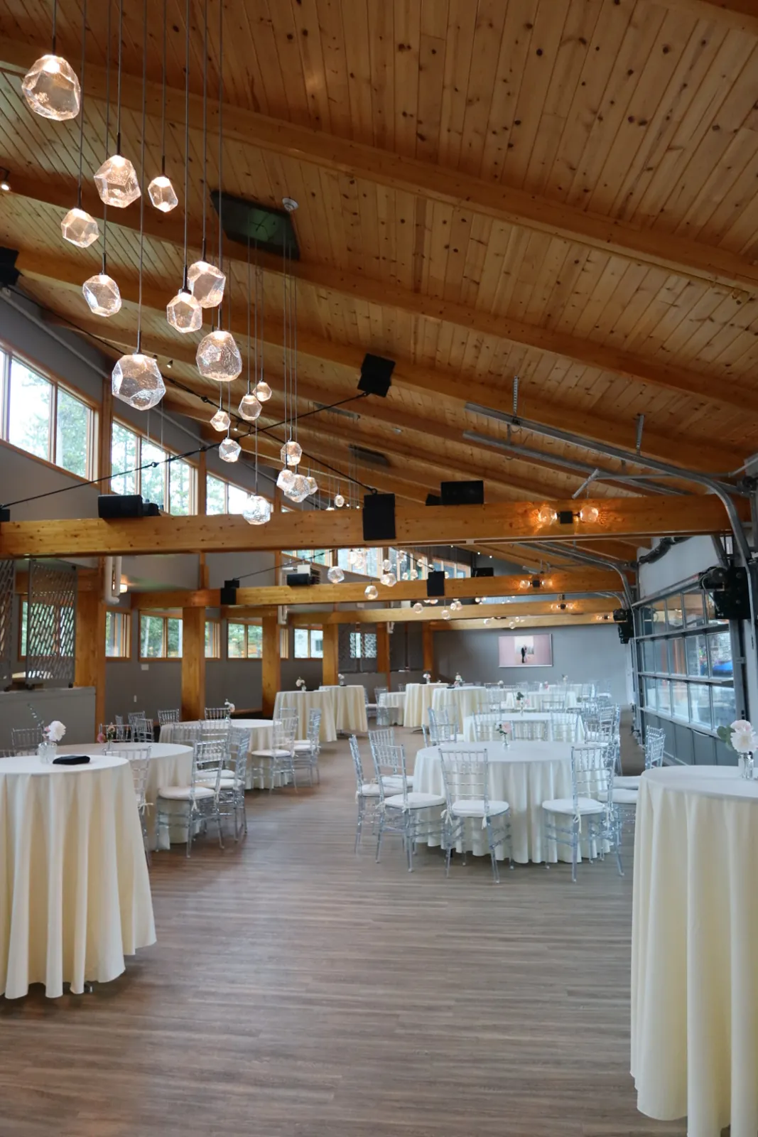 Reception room at Azuridge Estate Hotel in Priddis with a timber ceiling, crystal pendant lights and tables set in white linen