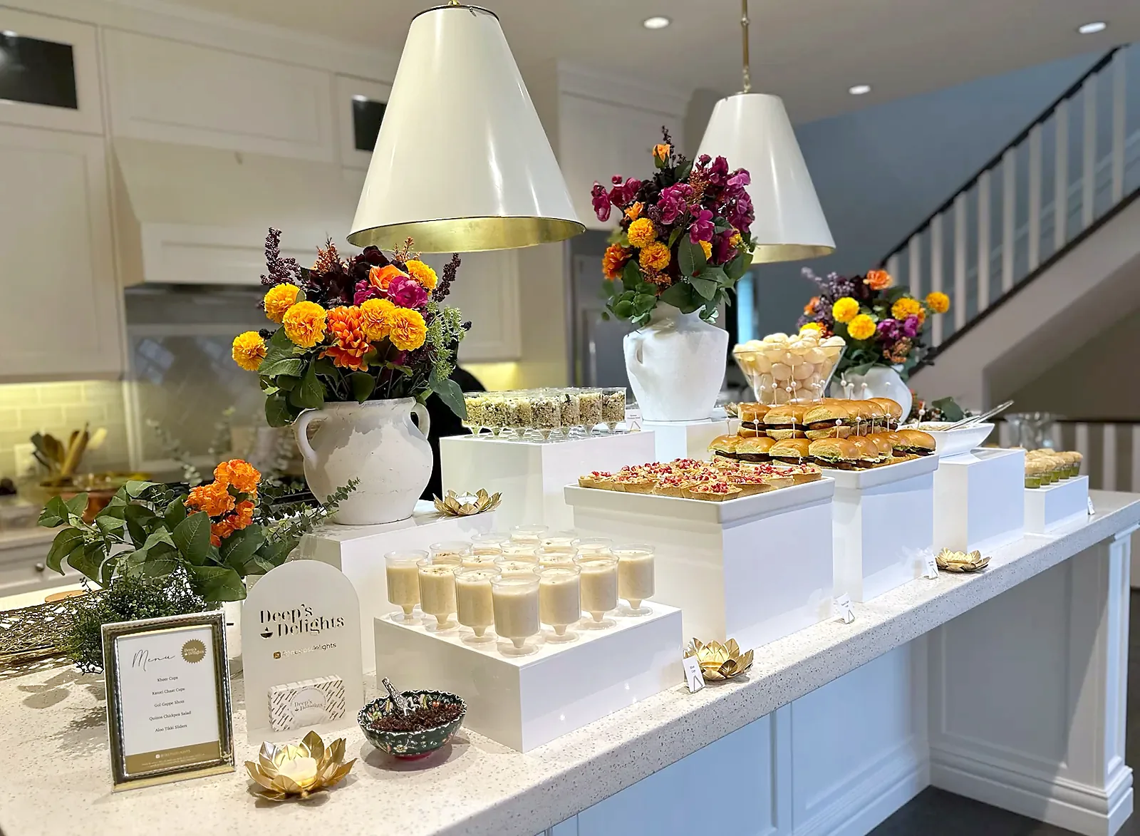 A styled catering display on a home kitchen island with marigolds and florals in Calgary