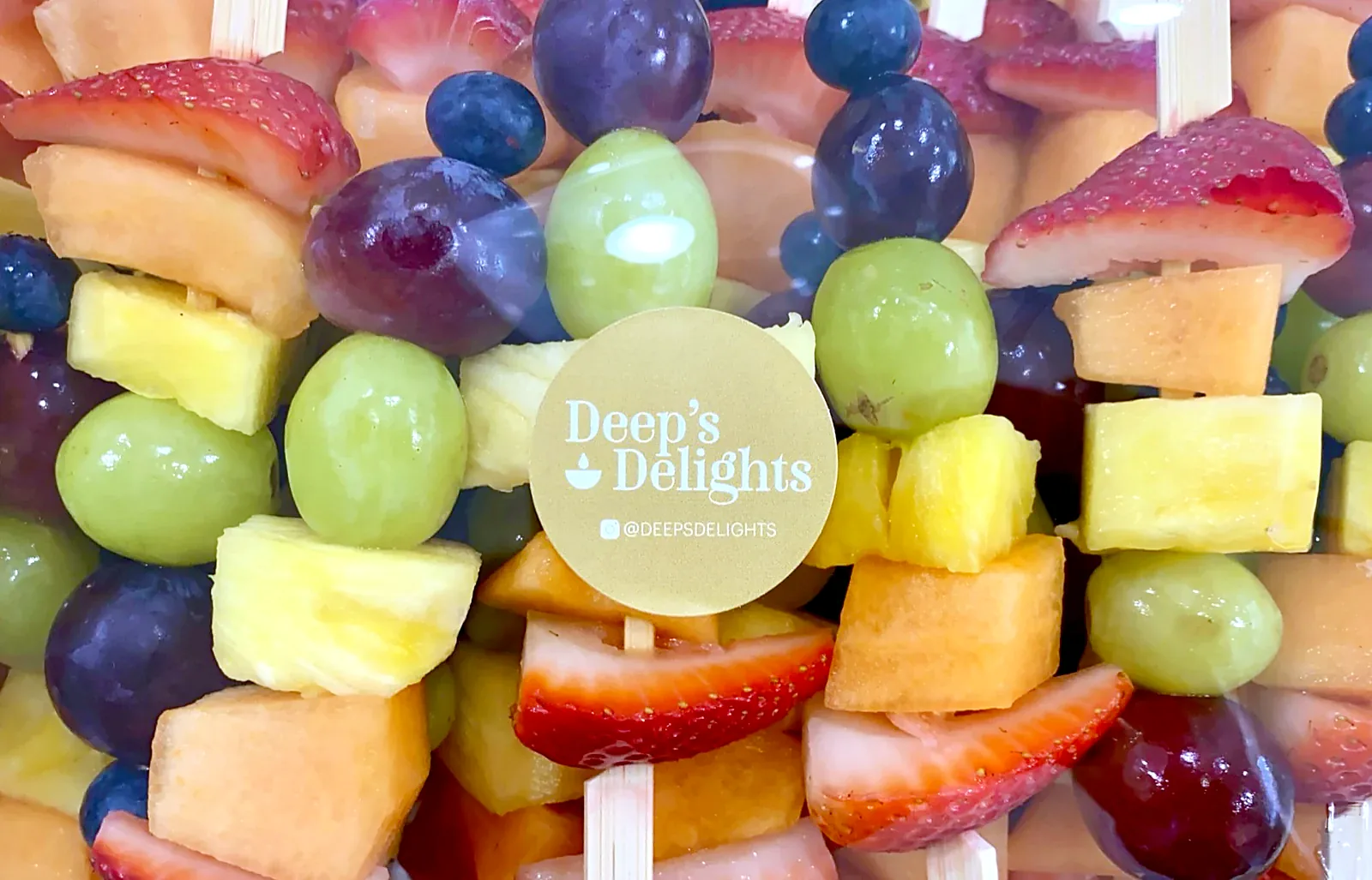 Colourful fruit skewers in a Deep's Delights branded container